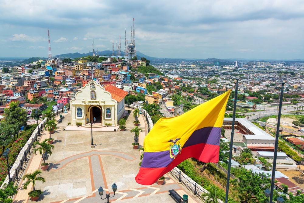 Ecuadorian flag on top of Santa Ana hill with a church and the city of Guayaquil in the background in Ecuador Ecuadorian flag on top of Santa Ana hill with a church and the city of Guayaquil in the background in Ecuador