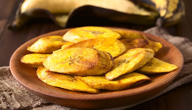 Fried slices of ripe plantains, traditional and popular snack and accompaniment in Central and Northern South America, photographed with natural light Fried slices of ripe plantains, traditional and popular snack and accompaniment in Central and Northern South America, photographed with natural light