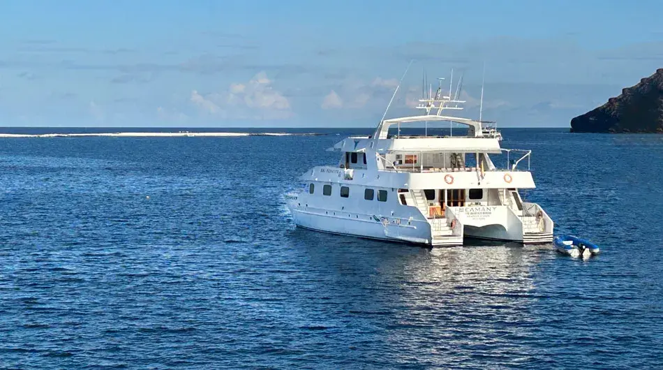 Seaman Journey ship cruising the Galapagos Islands with sand bar in the background Seaman Journey ship cruising the Galapagos Islands with sand bar in the background