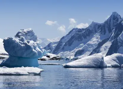 Antarctica%20hero14.jpg unique iceberg formation in calm bay with snowy mountains in background in Antarctica)