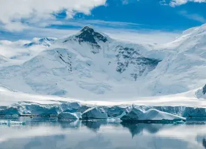 East%20Antarctica%202.jpg calm reflection in bay in Antarctica with snowy mountains down to waters edge)