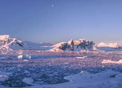 Antarctica-Mountains-Banner.jpg snowy Antarctic mountains and brash ice covering bay at sunrise)