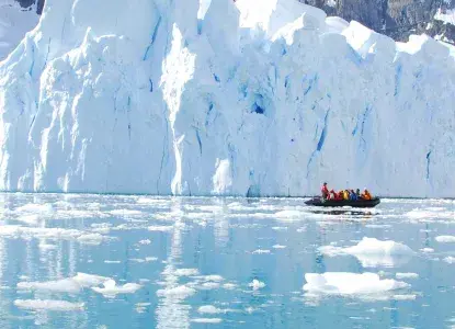 Antarctica-zodiac-banner.jpg zodiac with tourists in front of a glacier in Antarctica)