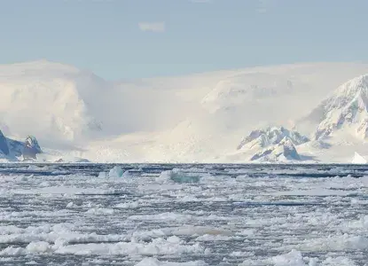 Antarctica_frozen-waters_hero_0.jpg Antarctic bay with brash ice, icebergs and snowy mountains in the background)